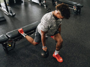 1UP Sports Marketing client Patrick Mahomes working out in the gym with kettlebells