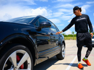 1UP Sports Marketing client Patrick Mahomes reaching for the door of a black Bentley