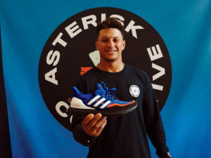 1UP Sports Marketing client Patrick Mahomes holding a blue adidas Boost sneaker