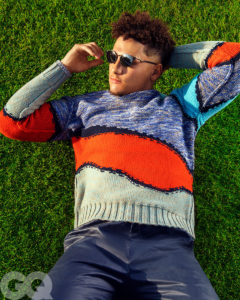1UP Sports Marketing client Patrick Mahomes lies in the grass wearing sunglasses for a GQ photoshoot