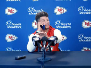 1UP Sports Marketing client Patrick Mahomes talks on his phone at a mock press event during a Head & Shoulders TV commercial