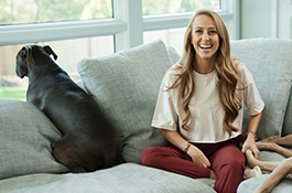 1UP Sports Marketing client Brittany Lynne Matthews sits on the couch with her dog
