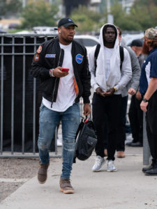 1UP Sports Marketing client Bradley Chubb walking with teammates as he looks at his phone